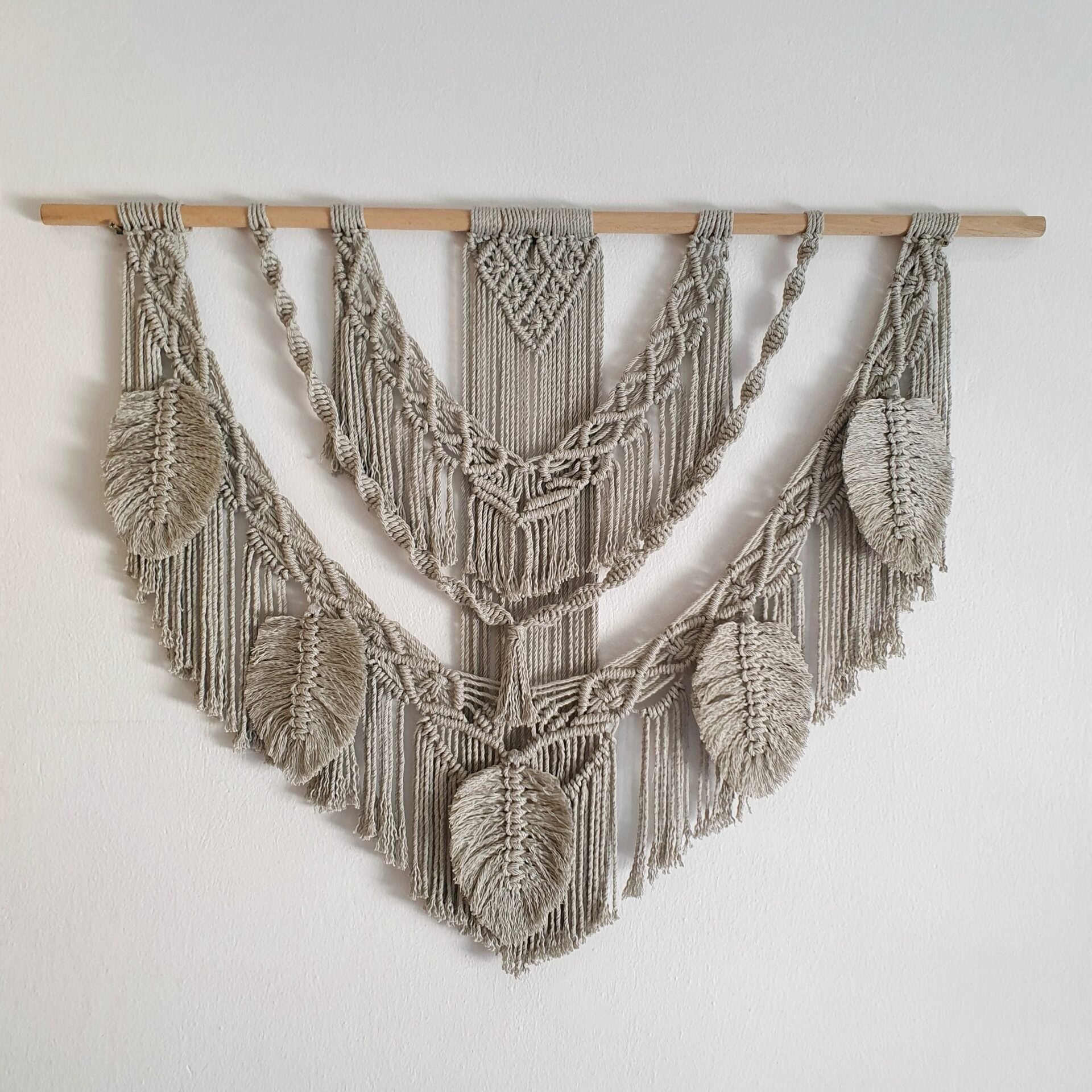 Décoration suspendue en macramé blanc cassé avec un support en bois