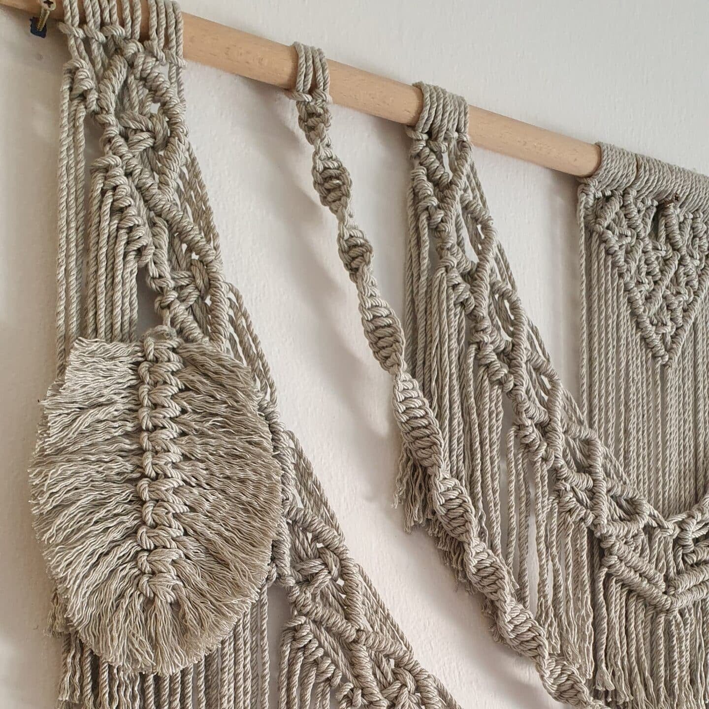Décoration suspendue en macramé blanc cassé avec un support en bois