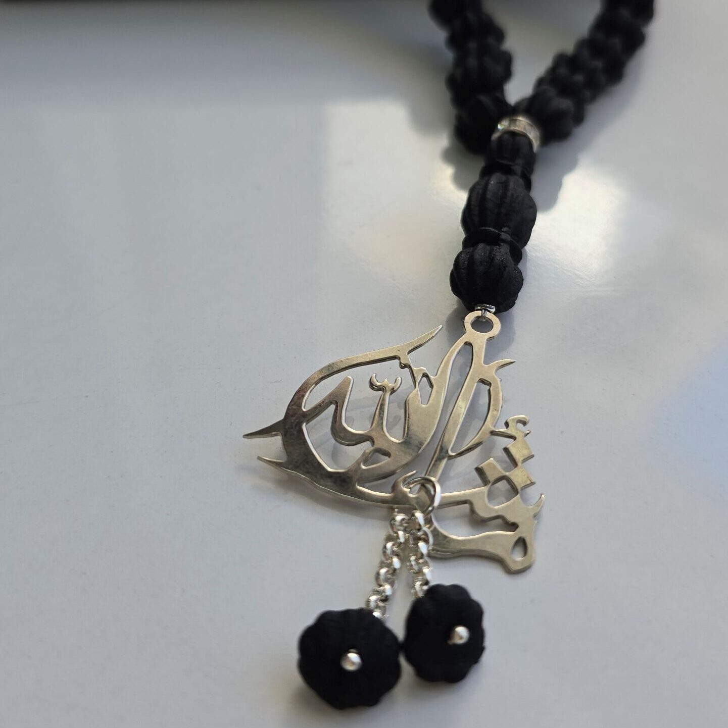 Chapelet « Sebha » en ambre noir parfumé avec 33 perles et calligraphie en arabe argent "Mashallah"