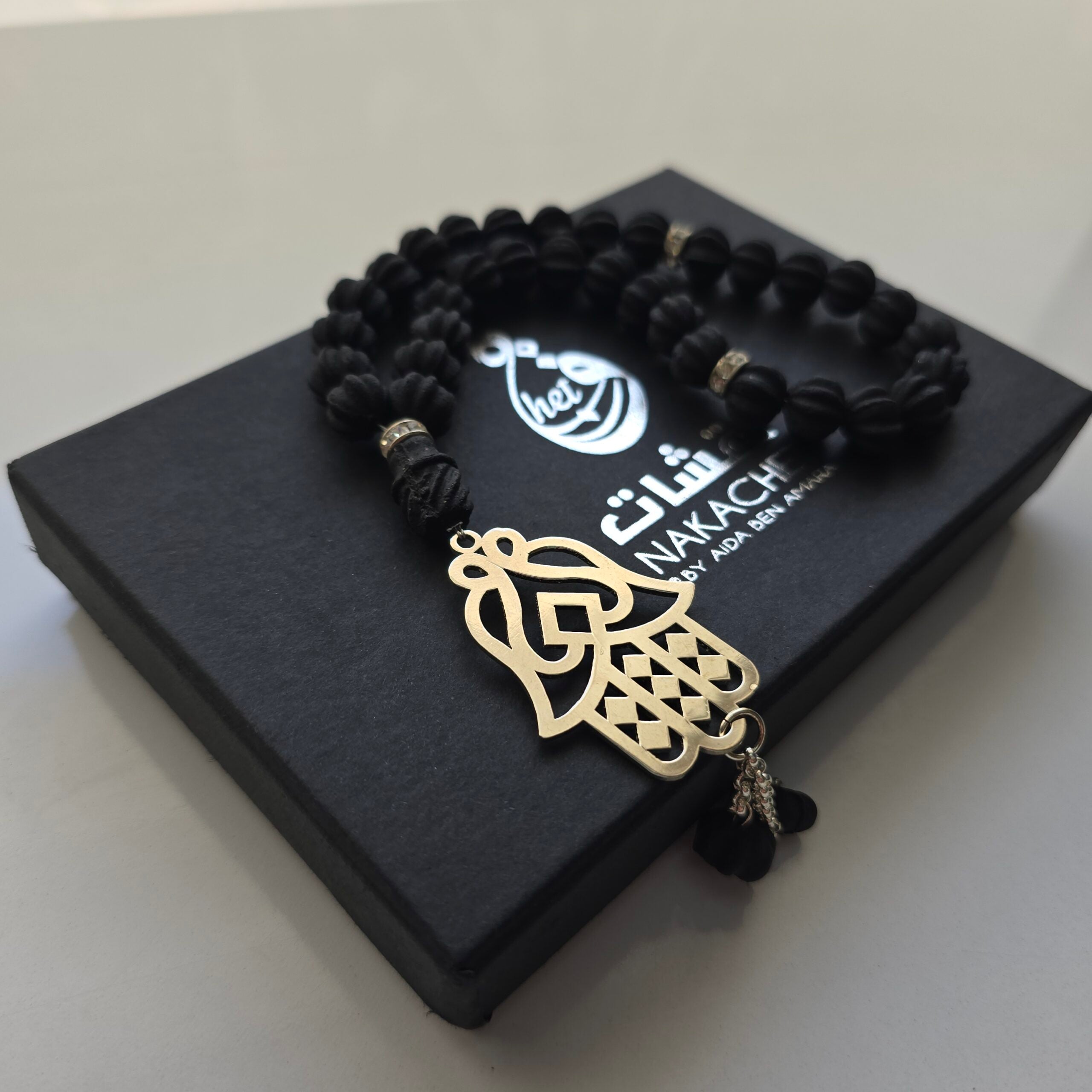 Chapelet « Sebha » en ambre noir parfumé avec motif Khomsa cuivre nickelé