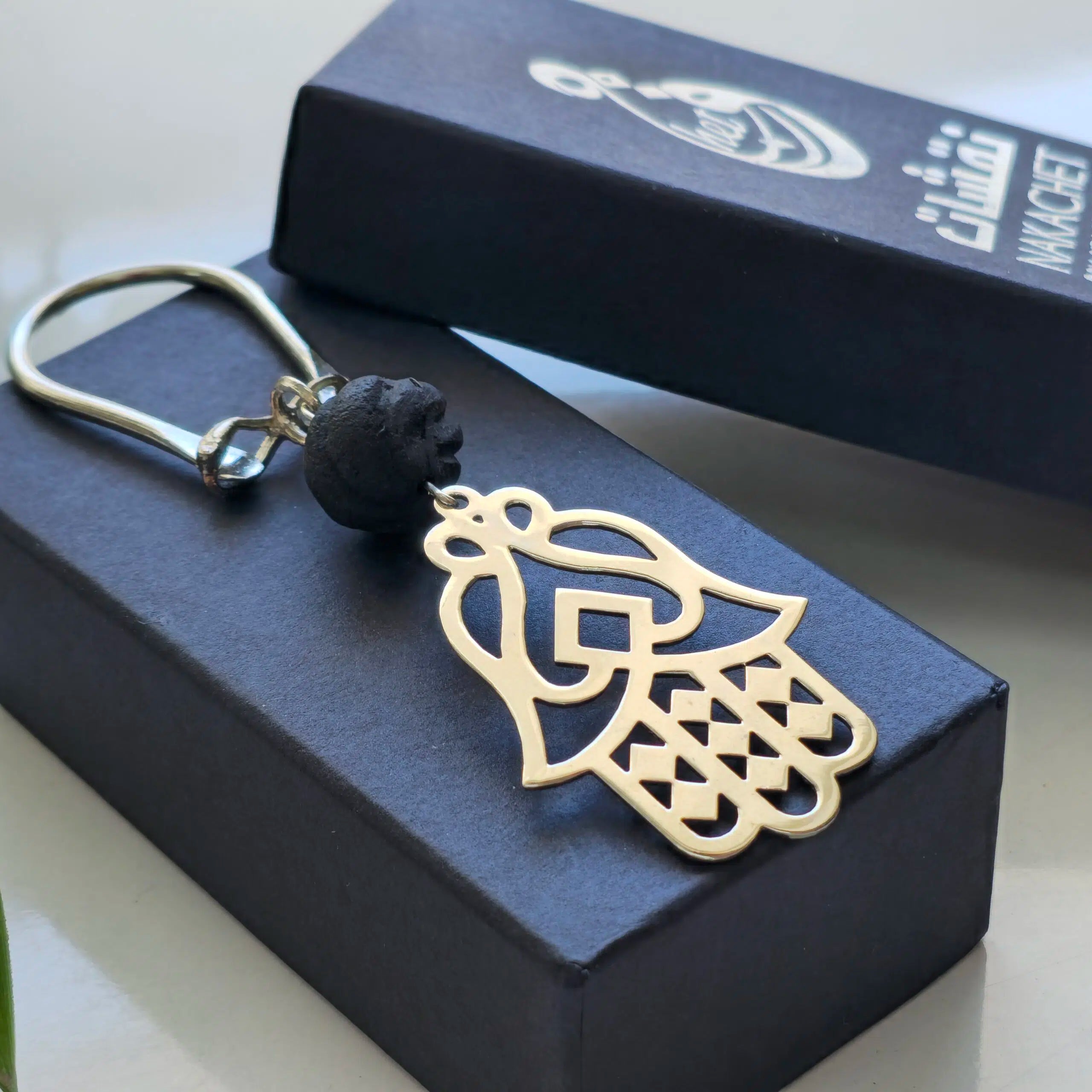 Porte clés KHOMSA orné d'une boule ambre noir