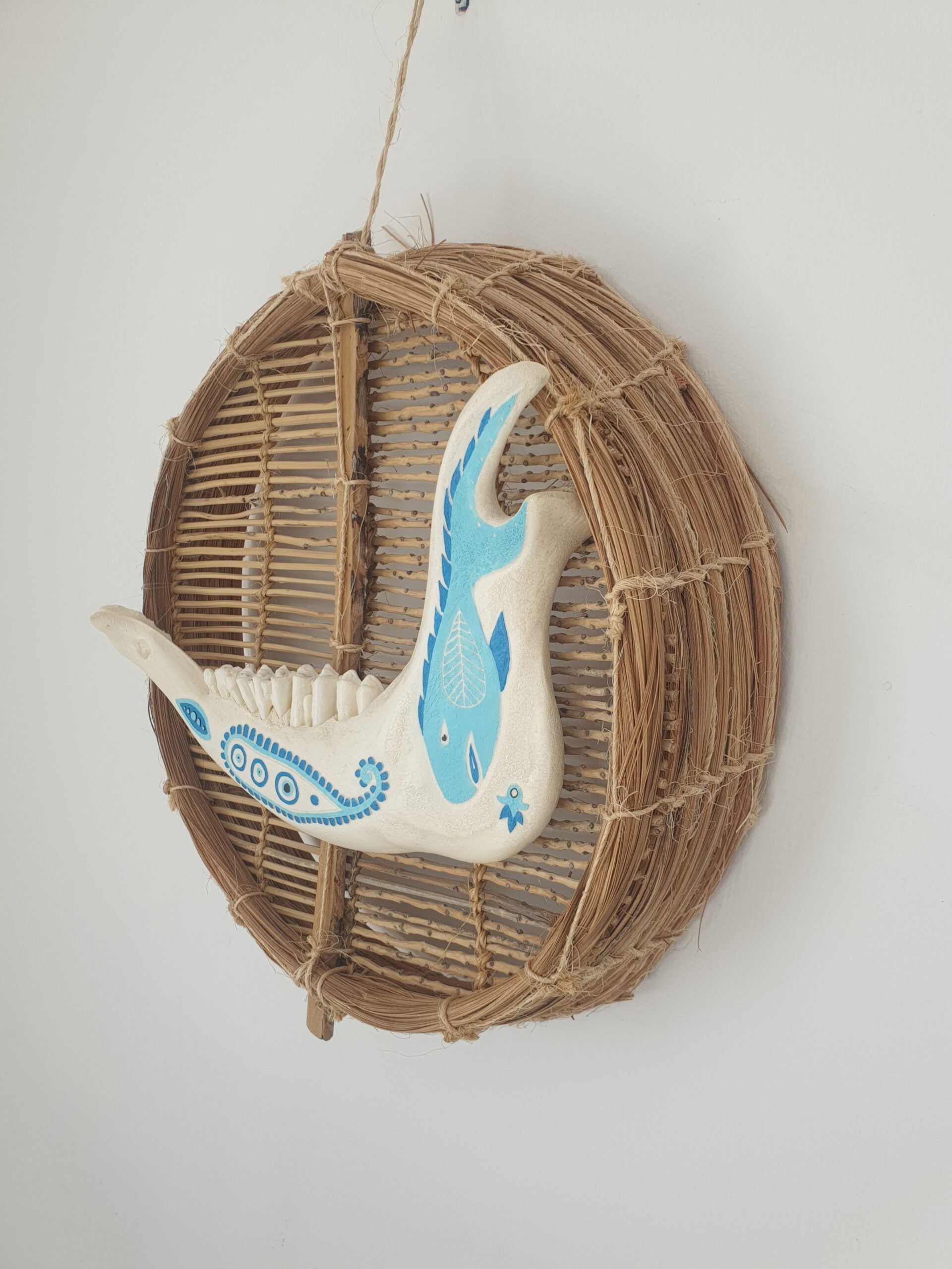 Mâchoire animale décorée bleu sur osier naturel