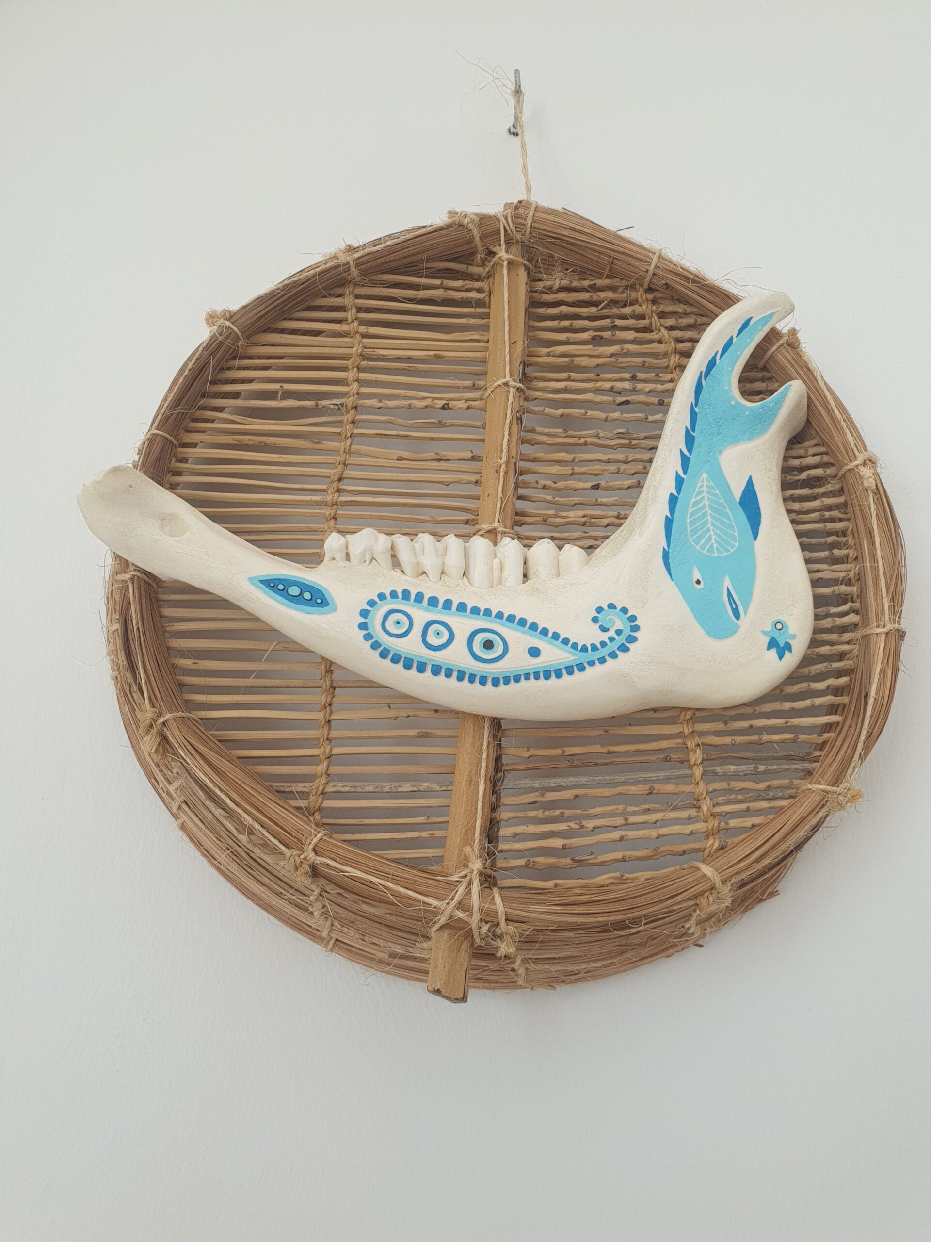 Mâchoire animale décorée bleu sur osier naturel