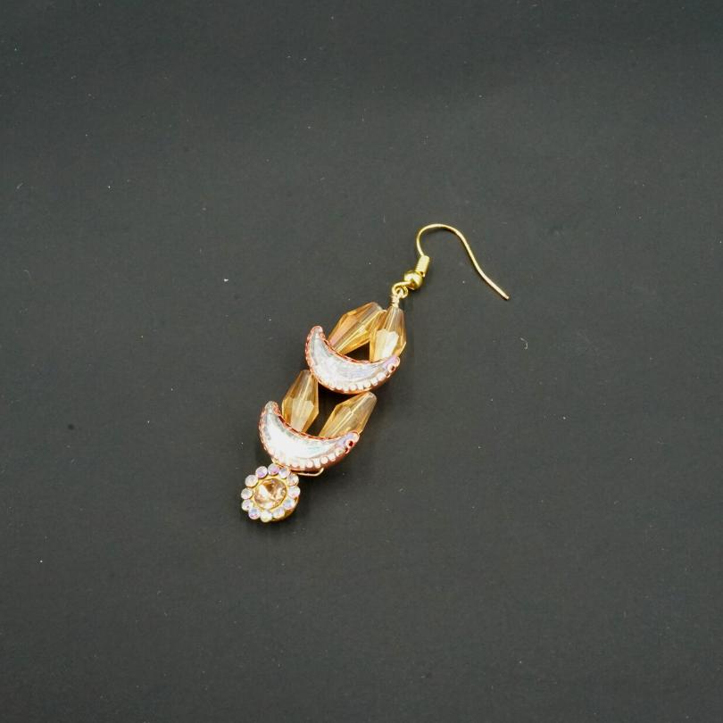 Gold-colored earrings, shaped like crescent moons and golden flowers in pearls