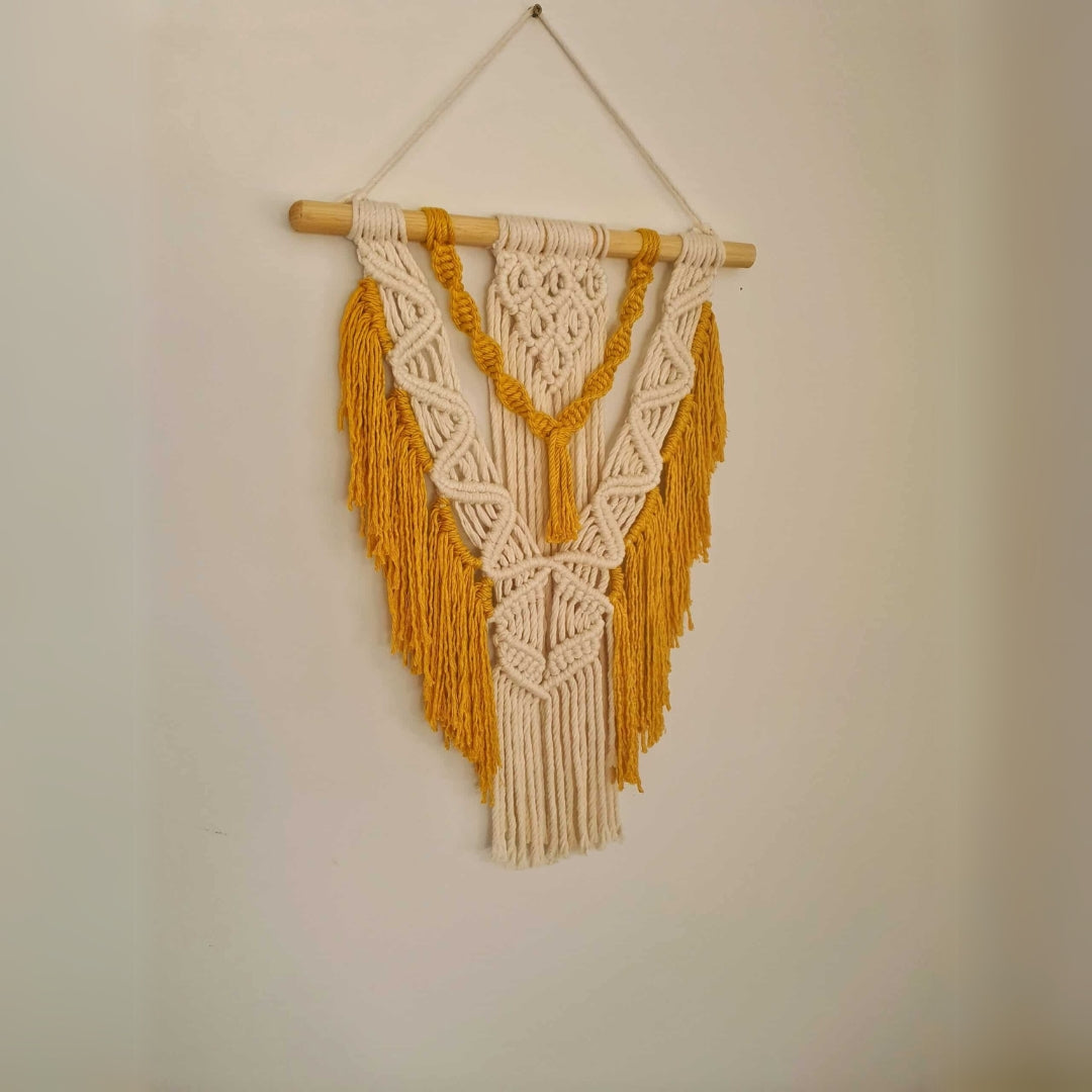Décoration suspendue en macramé blanc cassé et jaune avec un support en bois