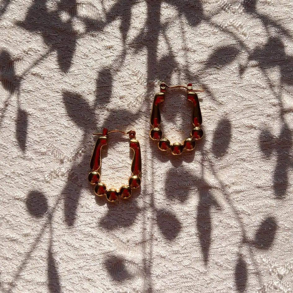 Boucles d'oreilles créoles dorées à billes – Élégance et modernité