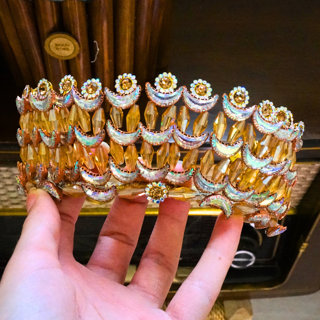 Gold-colored wedding crown modeled with crescent moons and golden flowers in pearls