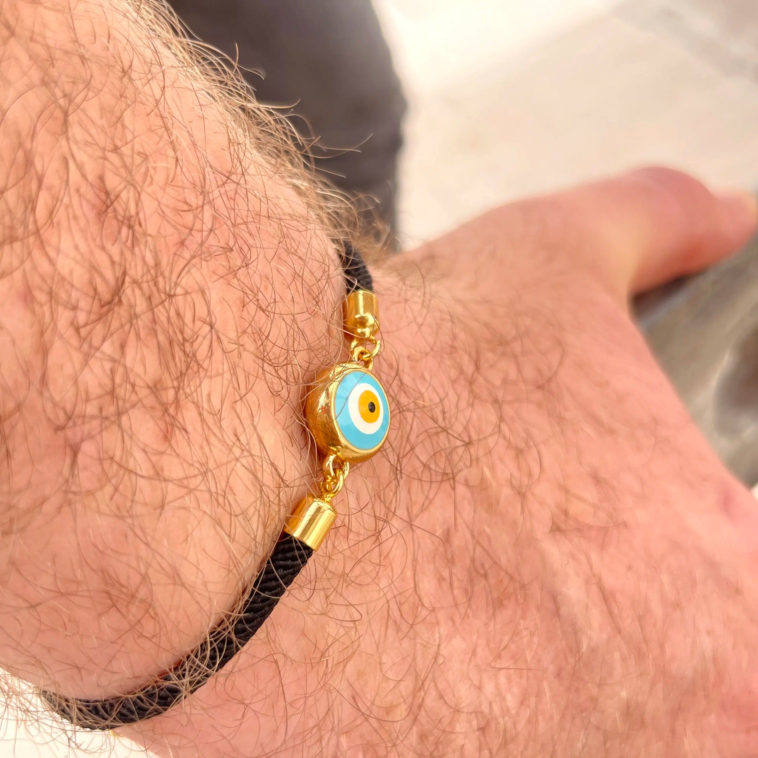 Bracelet artisanal noir avec le symbole de l’œil bleu