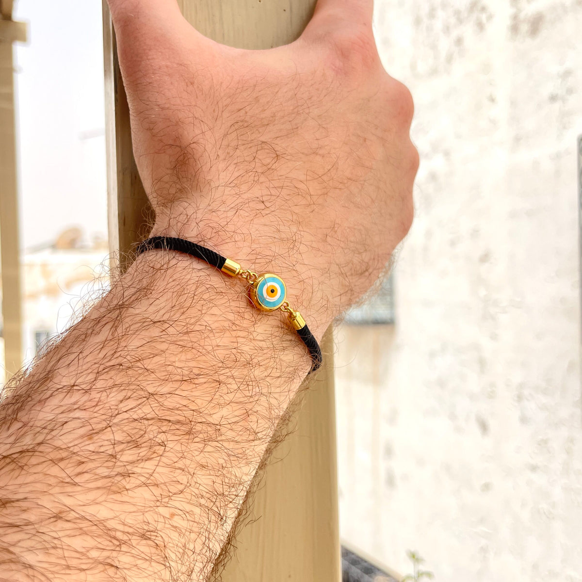 Bracelet artisanal noir avec le symbole de l’œil bleu