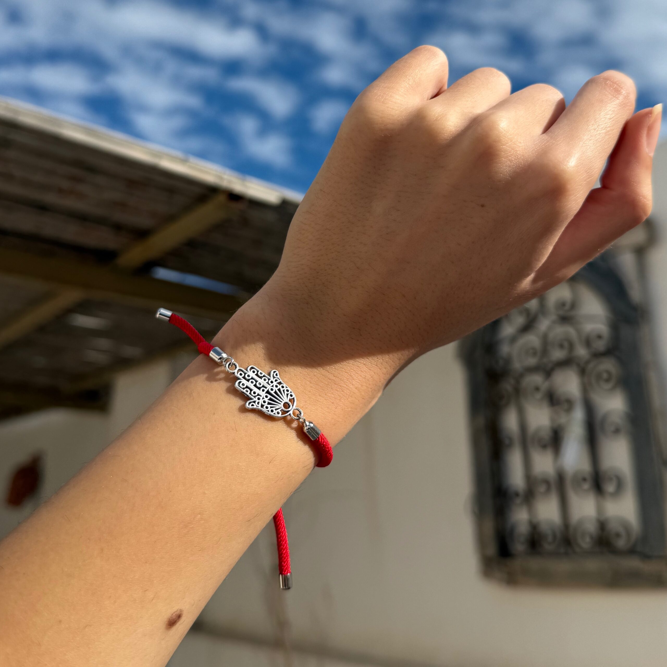 Bracelet cordon rouge motif khomsa ajustable — angle supp. Produit artisanal.