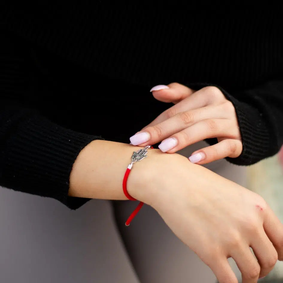 Bijou artisanal Tunisie — bracelet cordon rouge motif khomsa ajustable. Fait main par des artisans.