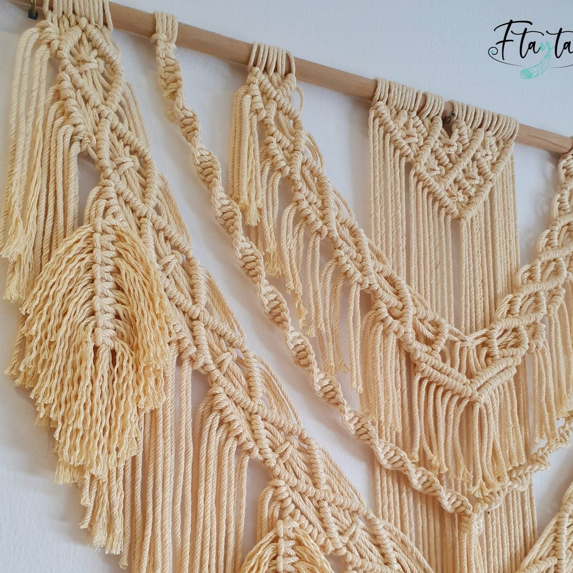 Décoration suspendue en macramé blanc cassé avec un support en bois