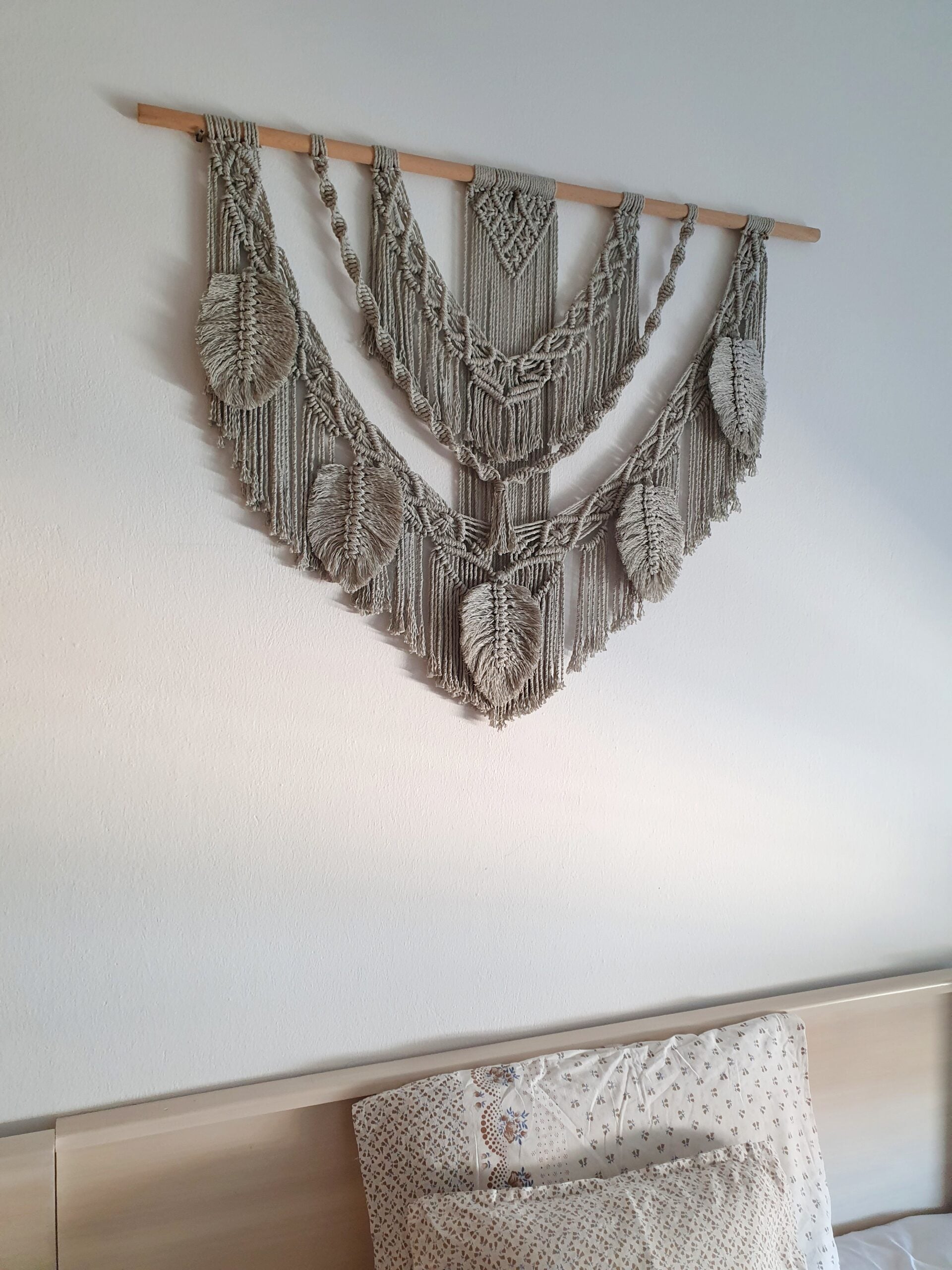 Décoration suspendue en macramé blanc cassé avec un support en bois