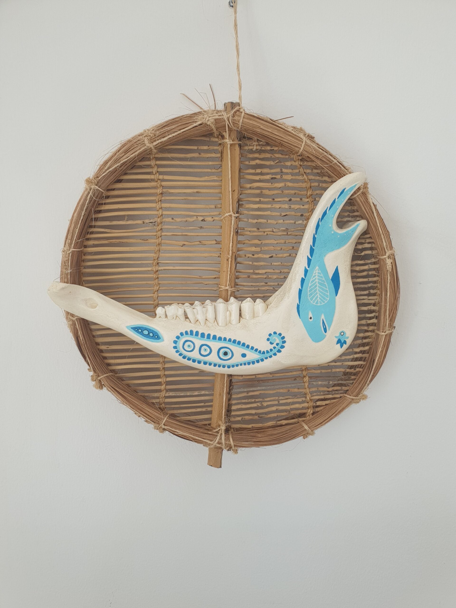 Mâchoire animale décorée bleu sur osier naturel