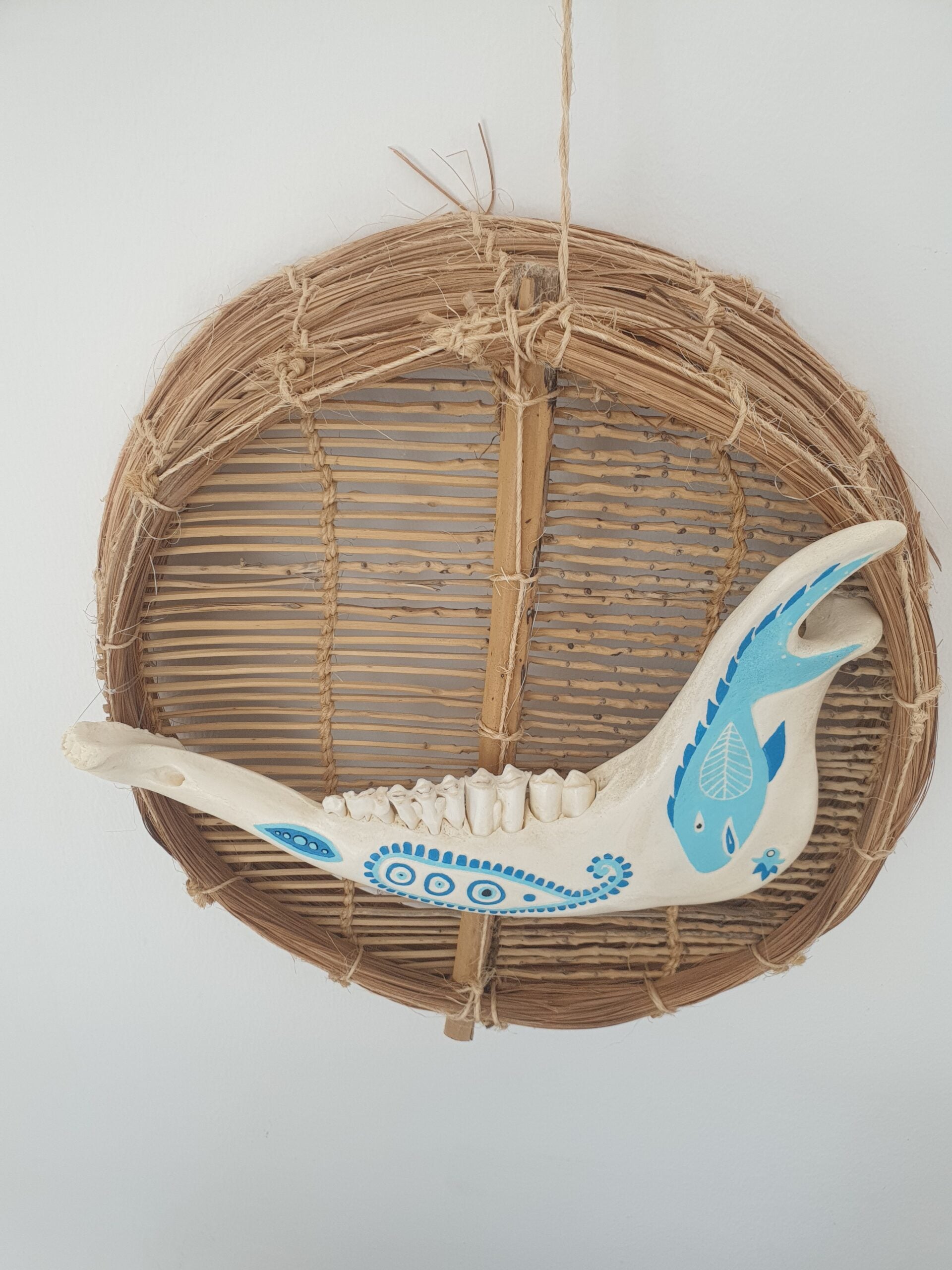 Mâchoire animale décorée bleu sur osier naturel