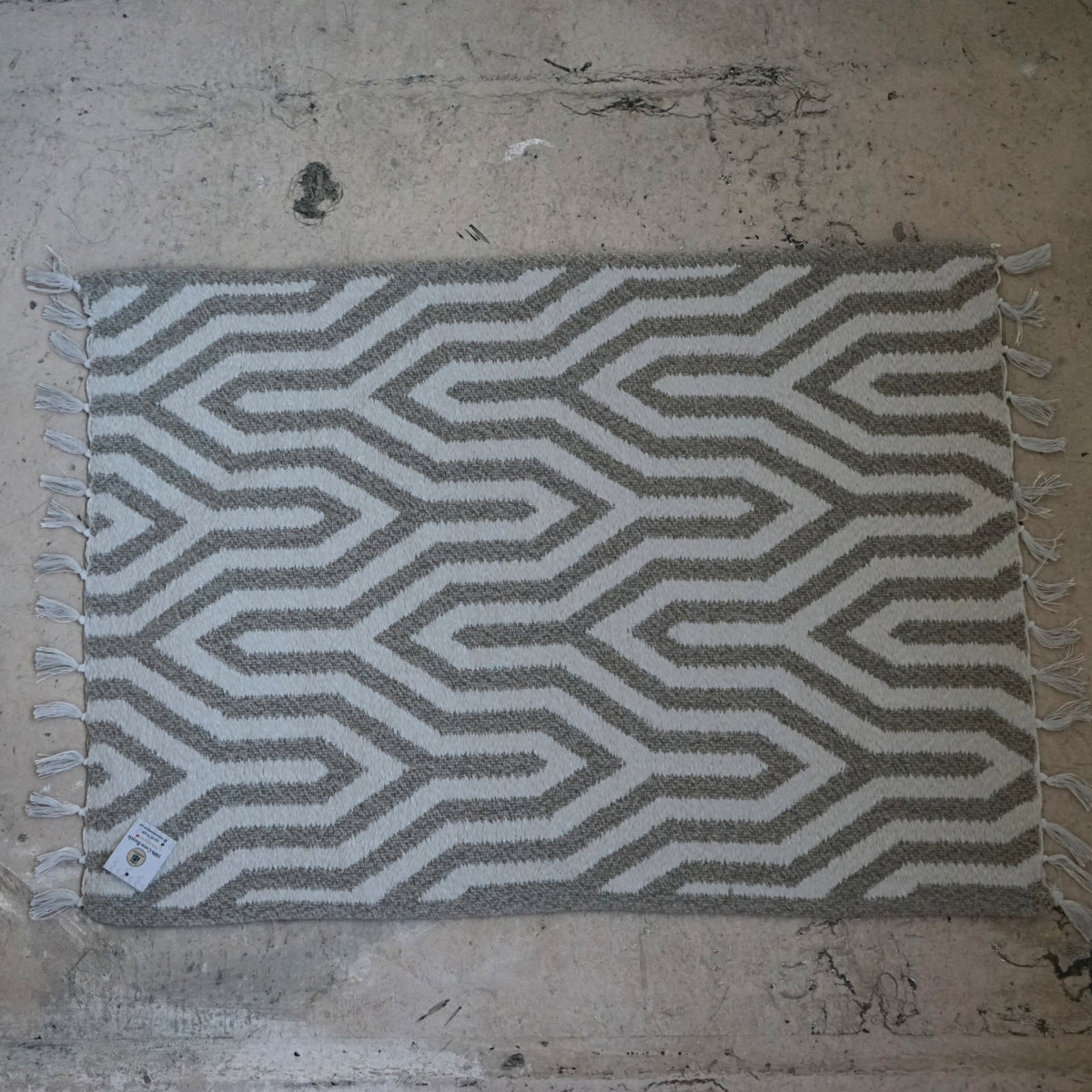 Tapis de bain gris en coton recyclé avec des petites pompons blanches (0.55 * 0.75 m)
