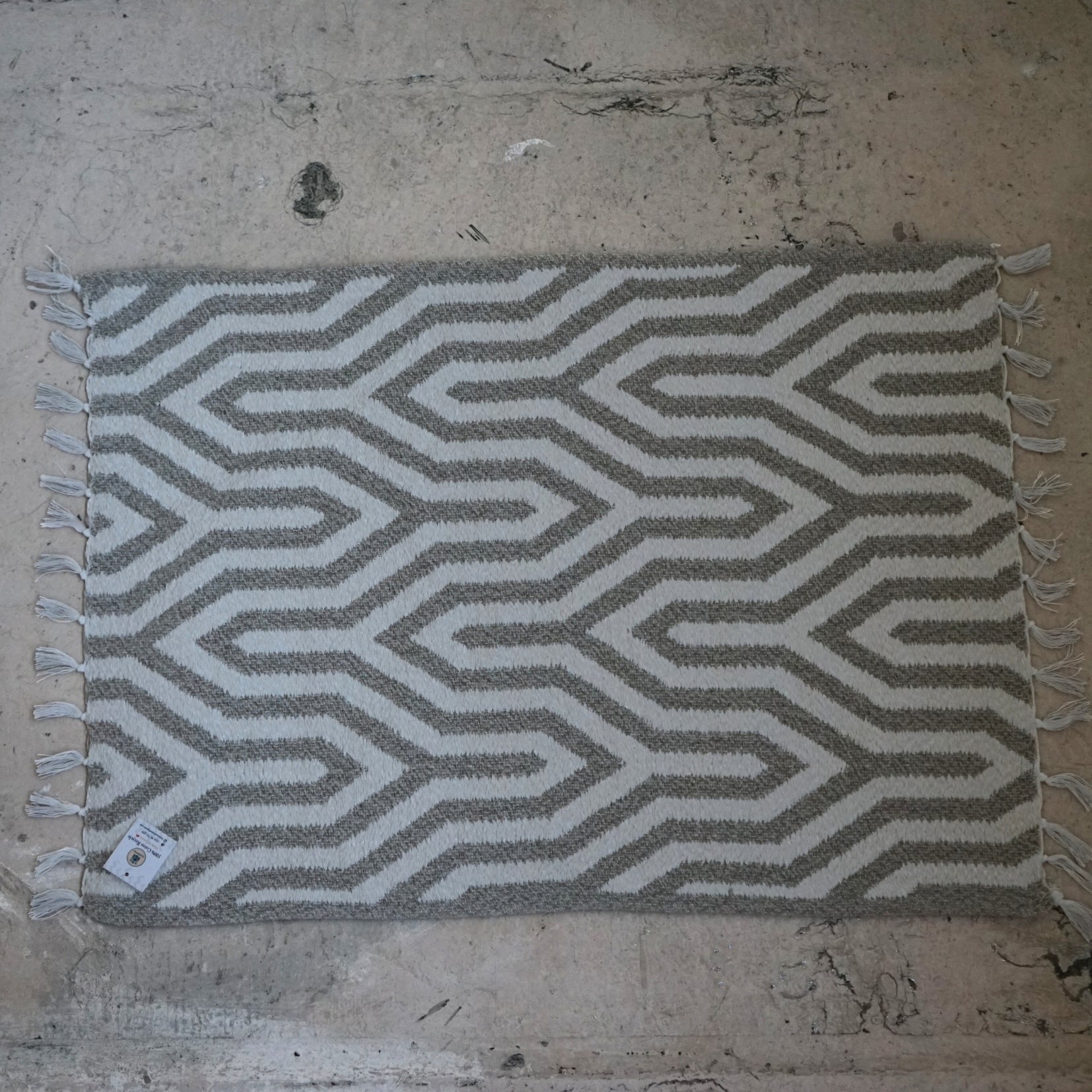 Tapis de bain gris en coton recyclé avec des petites pompons blanches (0.55 * 0.75 m)