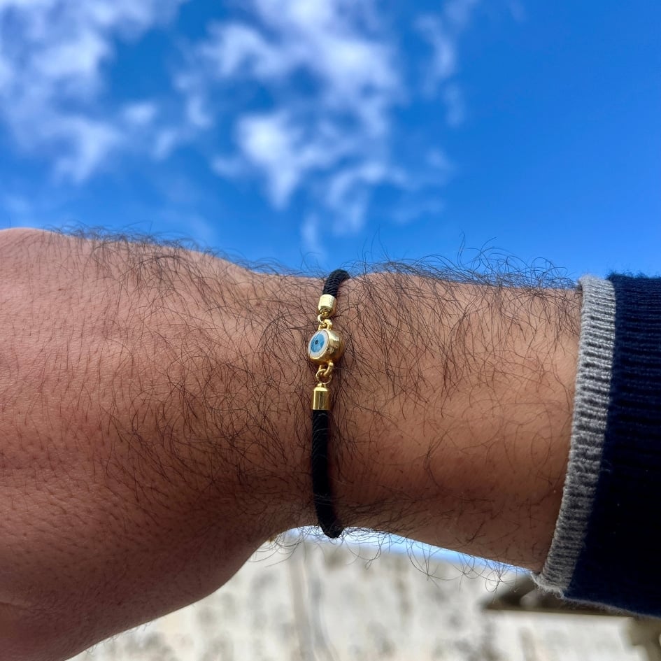 Bracelet artisanal noir avec le symbole de l’œil bleu