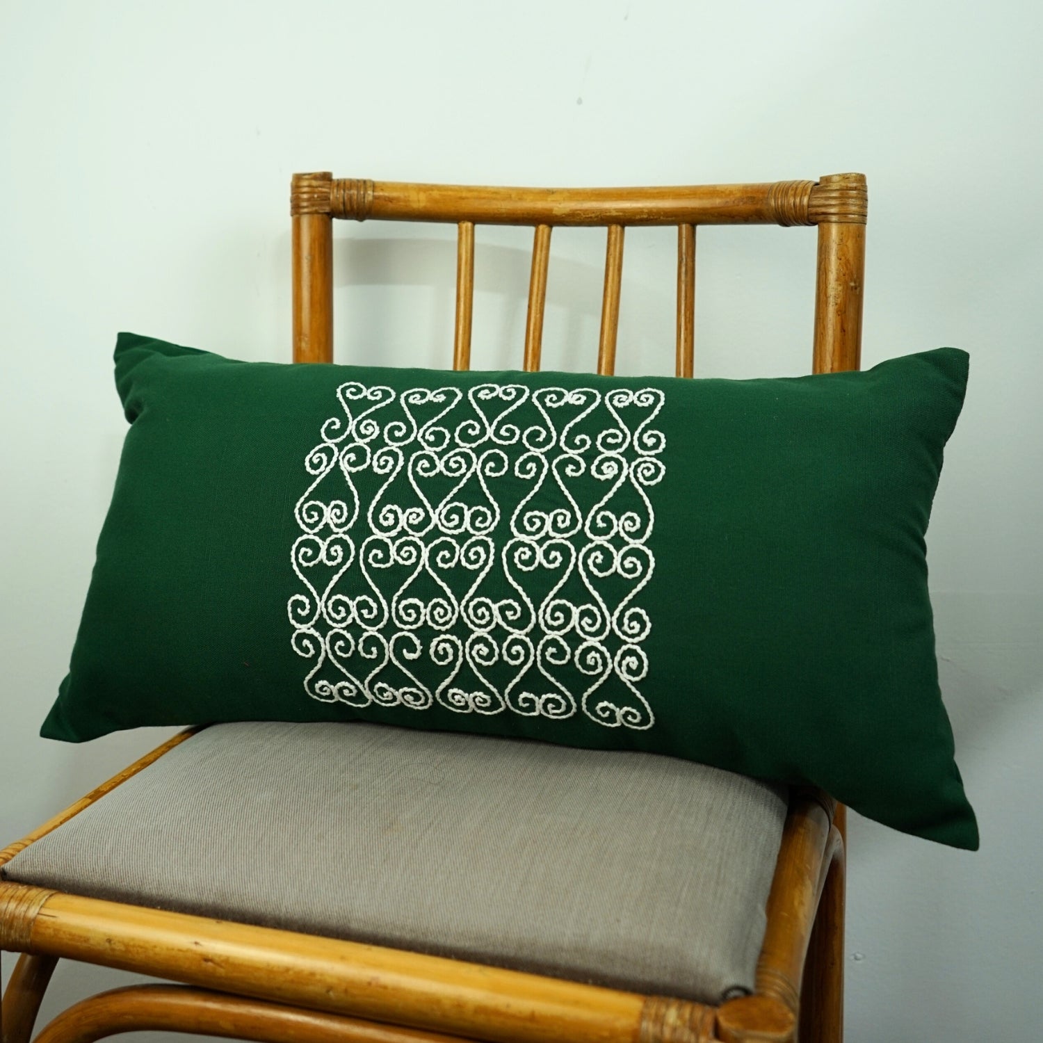 Coussin vert artisanal avec broderie blanche, élégance unique
