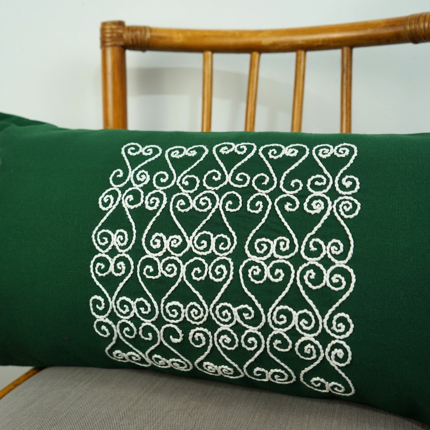 Coussin vert artisanal avec broderie blanche, élégance unique