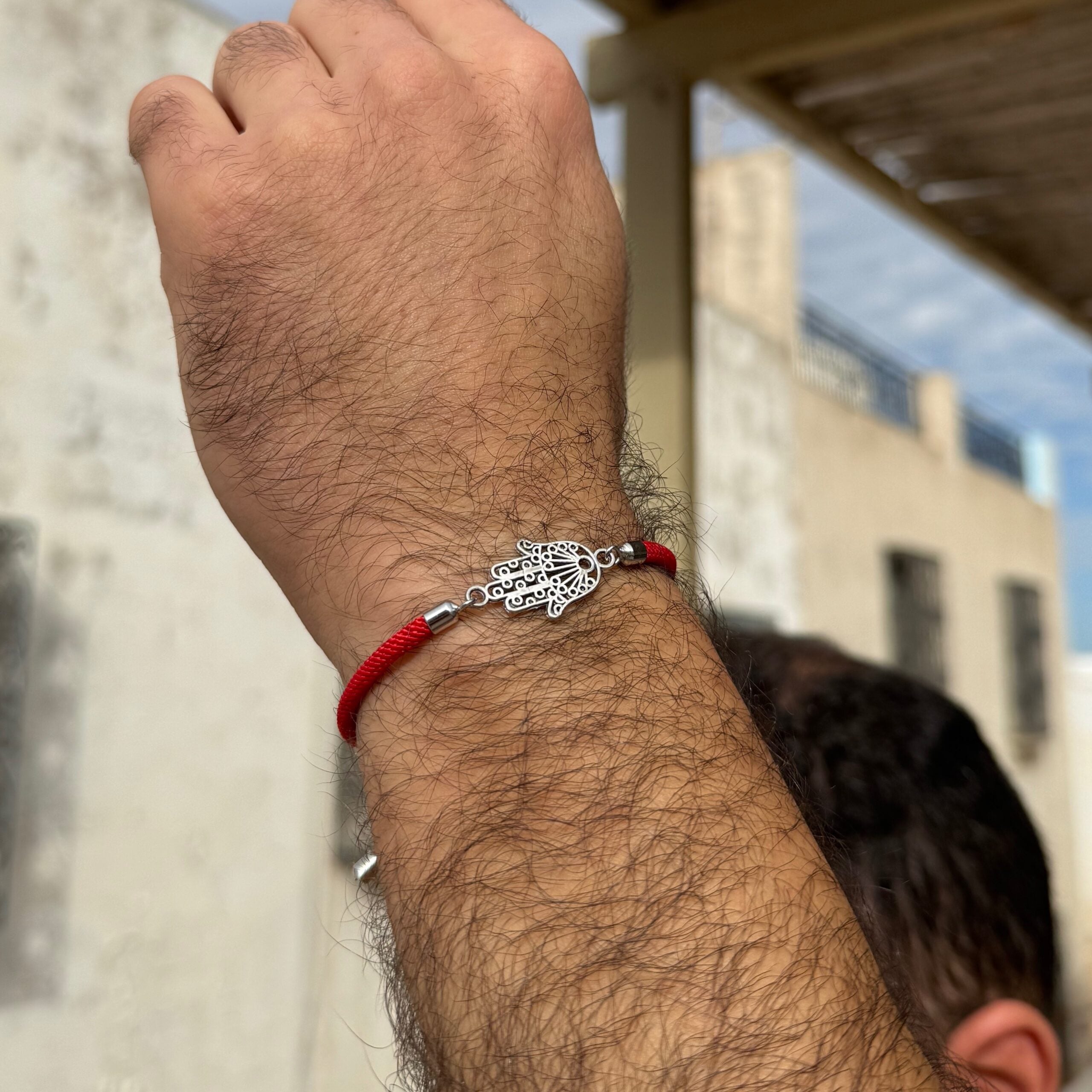 Bracelet cordon rouge motif khomsa ajustable — angle supp. Produit artisanal.